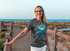 files/t-shirt-mockup-of-a-woman-with-glasses-standing-on-a-bridge-by-the-beach-m16523-r-el2.png