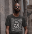 products/ringer-tee-mockup-of-a-man-with-sunglasses-posing-by-some-stone-buildings-27911.png