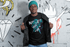 products/t-shirt-mockup-of-a-man-with-a-beanie-standing-by-wall-drawings-26434.png