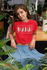 products/knotted-t-shirt-mockup-of-a-woman-at-a-table-surrounded-by-plants-27083_9f513639-e05b-42da-ac49-5bc7f31a523e.png