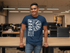 products/t-shirt-mockup-featuring-a-smiling-man-leaning-on-a-desk-at-the-office-28959.png